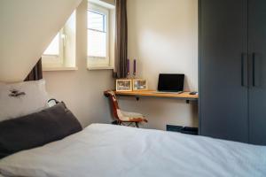 a bedroom with a bed and a desk with a laptop at Baude III in Braunlage