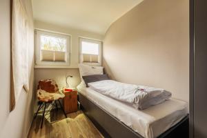 a small room with a bed and two windows at Baude III in Braunlage +8 photos