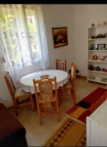 a kitchen with a table and chairs and a window at Apartman SLADJANA Vrnjacka Banja in Vrnjačka Banja