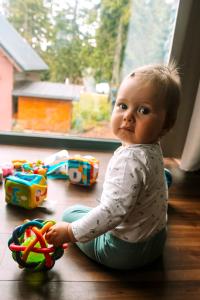 ein Baby auf dem Boden, das mit einem Spielzeug spielt in der Unterkunft Chata MartinSki Martinske hole in Martinské Hole
