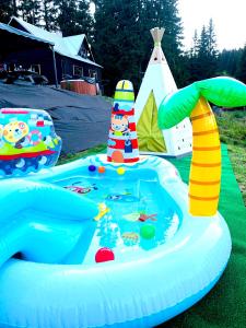 una piscina gonfiabile con un faro giocattolo nell'erba di Chata MartinSki Martinske hole a Martinské Hole