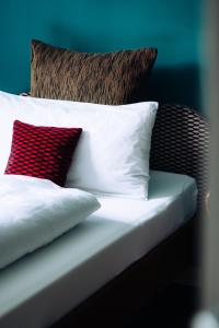 a bed with white pillows and a red pillow at Molo Rouge in Wunsiedel