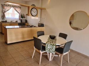 a kitchen and dining room with a table and chairs at Weavers Nest 34 in Windhoek