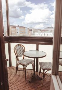 a table and chairs on a balcony with a window at Hotel Emilia in Hämeenlinna