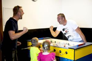 dos hombres y dos niños jugando con una mesa de ping pong en Chata MartinSki Martinske hole en Martinske Hole