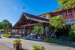 a resort with a red building and palm trees at Hotel Raul's in Gaspar