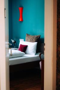 a blue room with a bench with pillows and a red lamp at Molo Rouge in Wunsiedel