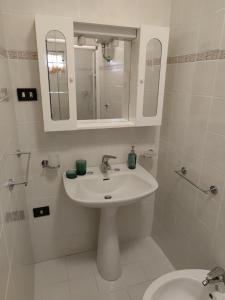 a white bathroom with a sink and a mirror at B&B NONNA GINA in Manoppello