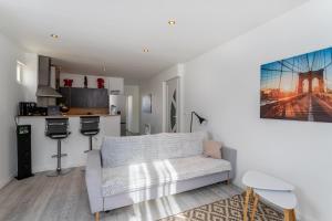 ein Wohnzimmer mit einem Sofa und einer Küche in der Unterkunft T2 L'Oiselet *Bourgoin-Jallieu* in Bourgoin