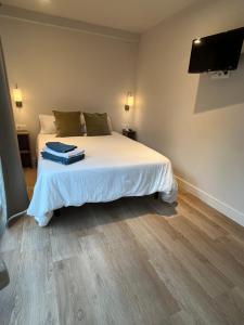 a bedroom with a bed with a tv on the wall at LA CASA DE INVITADOS in Zaragoza