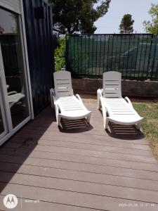 two white lounge chairs sitting on a deck at LA CASA DE INVITADOS in Zaragoza