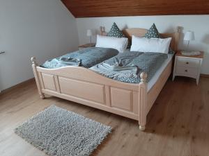 a bedroom with a large wooden bed with pillows at Ferienwohnung Marion in Wallenborn