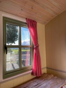 Habitación con ventana con cortina roja en Mountain View Shepherds Hut en Kilkeel