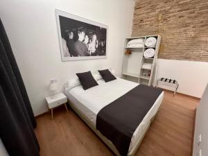 a bedroom with a large bed and a brick wall at Old Town Flats Casa Burguerini in Valencia