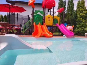 un parque infantil con tobogán y equipo de juegos en Atlantic aqua resort, en Chłopy