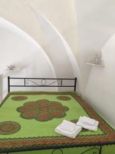 een slaapkamer met een bed met twee handdoeken erop bij La dimora dei nonni in Tuglie