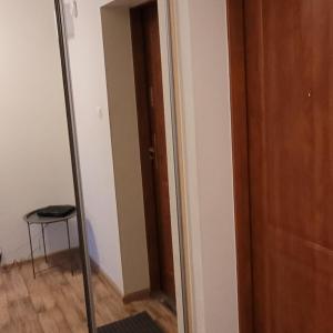um espelho num quarto com um banco ao lado de uma porta em Apartament em Nakło nad Notecia