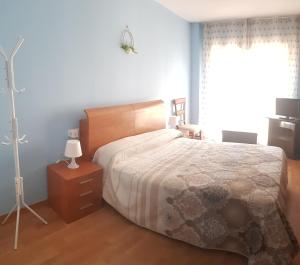 1 dormitorio con cama, lámpara y ventana en Apartamento Alhondiga Hervás, en Hervás
