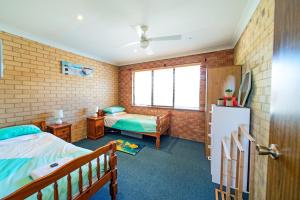 Schlafzimmer mit einem Bett, einem Schreibtisch und einem Kühlschrank in der Unterkunft Comfortable Central Unit in Geraldton