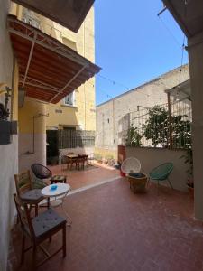 un patio avec des tables et des chaises et un bâtiment dans l'établissement Le camere del Nonno Luigi, à Naples