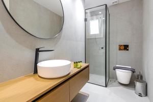 uma casa de banho com um lavatório branco e um espelho. em Phaedrus Living: Luxury Flat Panormou em Atenas