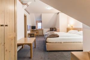 a hotel room with a bed and a desk at Hotel Krvavec in Cerklje na Gorenjskem