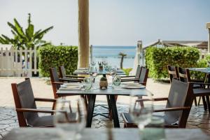 a table with glasses on it next to the beach at Atlantica Bay - Adults Only in Limassol