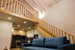 a living room with a blue couch and a staircase at La villa events in Amalias