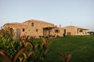 a large stone house with a grass yard at La villa events in Amaliás