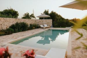 a swimming pool with two chairs and an umbrella at La villa events in Amalias