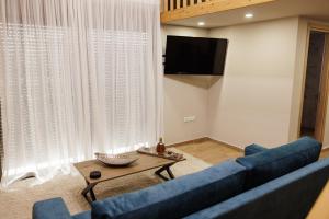 a living room with a blue couch and a table at La villa events in Amalias