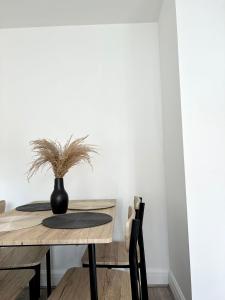a dining room table with a black vase on it at Central Watford Duplex in Watford