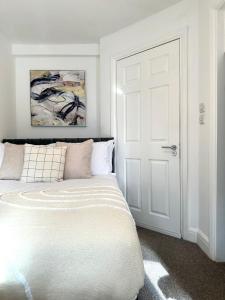 a bedroom with a white bed and a white door at Central Watford Duplex in Watford