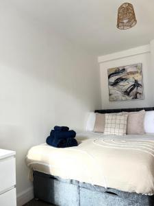 a bedroom with a bed with blue towels on it at Central Watford Duplex in Watford