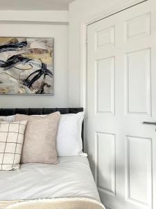 a white bedroom with a bed and a door at Central Watford Duplex in Watford