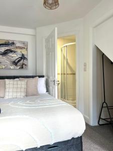 a bedroom with a large white bed and a mirror at Central Watford Duplex in Watford