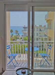 a balcony with a table and chairs and a view of the ocean at Cosy studio à 2 pas de la plage in Nice