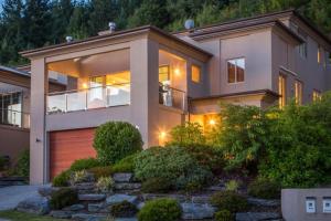a house with a garage in front of it at Queenstown Grandview with Spa Pool in Queenstown