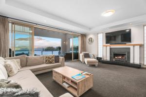 a living room with a couch and a fireplace at Queenstown Grandview with Spa Pool in Queenstown
