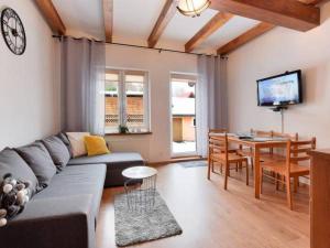 a living room with a couch and a table at Apartamenty Przy Deptaku in Karpacz