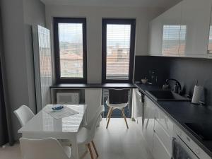 eine Küche mit einem Tisch und einem weißen Tisch und Stühlen in der Unterkunft Апартамент ДОРА in Kasanlak