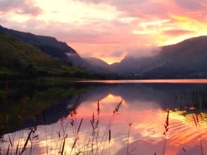 a view of a lake at sunset with mountains at Pen-Y-Bont Hotel in Tal-y-llyn