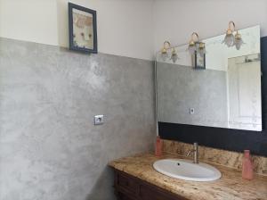 y baño con lavabo y espejo. en SUITE SPA PRIVATIF extérieur 66 Perpignan Nord en Pia