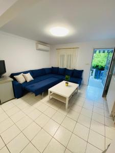 sala de estar con sofá azul y mesa en Koker's Place en Tesalónica