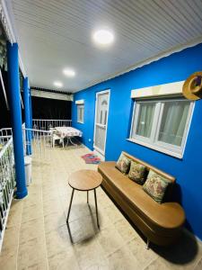 Koker's Place في سلانيك: غرفة معيشة مع أريكة والجدار الأزرق