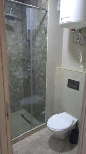 a bathroom with a toilet and a glass shower at Zenata Tower Ain Harrouda Mohemadia in Mohammedia