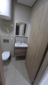 a bathroom with a sink and a toilet and a mirror at Zenata Tower Ain Harrouda Mohemadia in Mohammedia