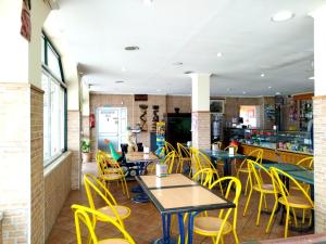 a dining room with tables and yellow chairs at Nefama Pensao in Ourique