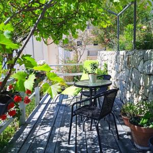 a patio with a table and chairs and a stone wall at Apartments Ana in Brela