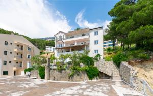 a large white building on a hill with trees at Apartments Ana in Brela +48 photos